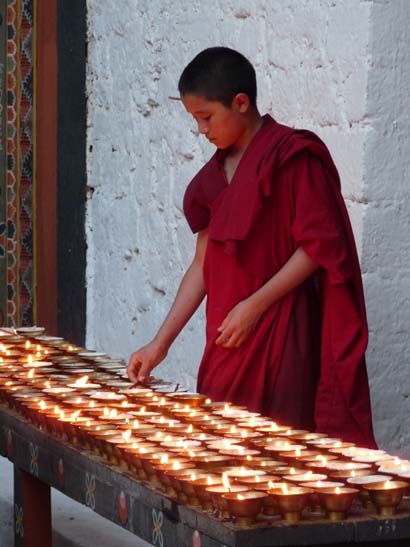 Mönch und Butterlampen im Punakha Dzong, Bhutan